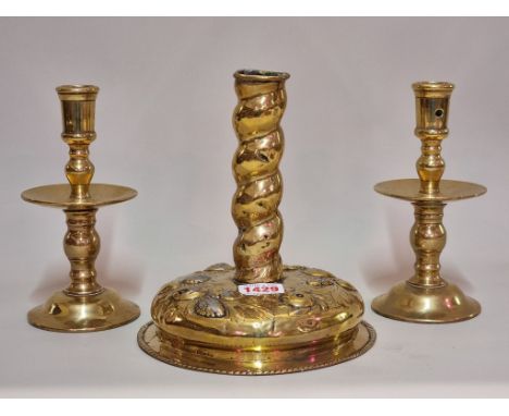 An antique brass embossed brass candlestick, probably Dutch, 19cm high, (repairs); together with another pair of brass candle