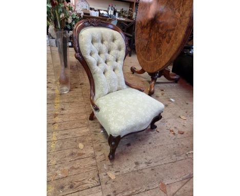 A Victorian carved walnut and button upholstered low occasional chair.&nbsp; 