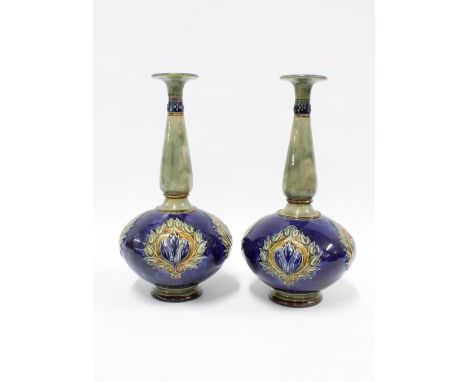 A pair of Royal Doulton stoneware bottle vases, blue ground with Art Nouveau floral patterns, with slender green marbled neck
