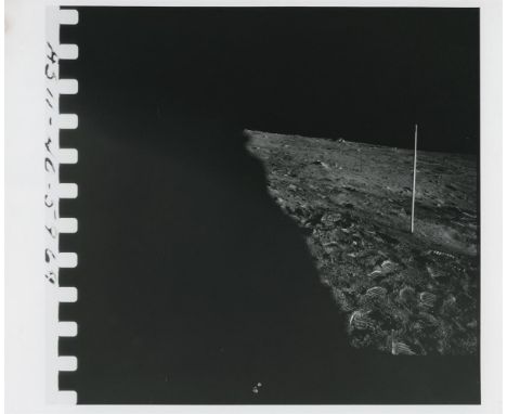 
	
		Neil Armstrong
		A view of the landing site with the Solar Wind Collector and a portion of Neil Armstrong's suit at bott