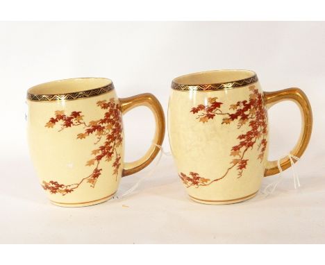 A pair of Japanese pottery barrel shaped mugs decorated in red and gilt with maple leaf branches and a porcelain plate painte