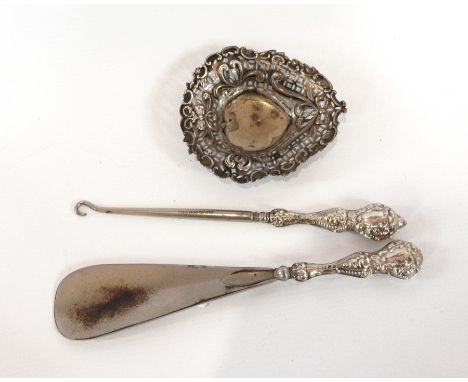 A small silver heart-shaped bonbon dish, a silver glass-capped jar, a silver-handled shoe horn and a button hook (4) 