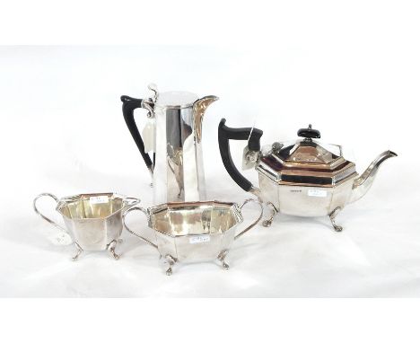 A silver-plate three-piece tea service, of tapering faceted form comprising teapot, sugar basin and milk jug, raised on pad f