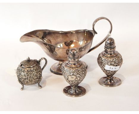 A pair of pepperettes, repousse design with blank cartouche on circular foot, a silver plated gravy boat, an EPNS mustard pot