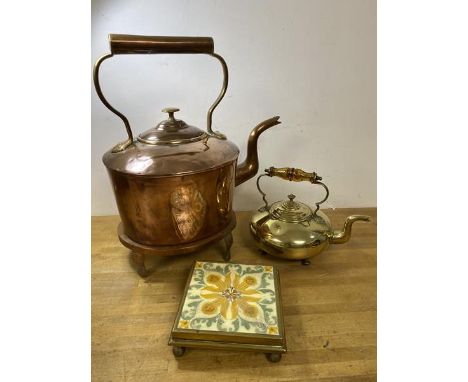A copper kettle and trivet, kettle measures 36cm high, along with brass footed kettle with brass and tile stand (a lot)