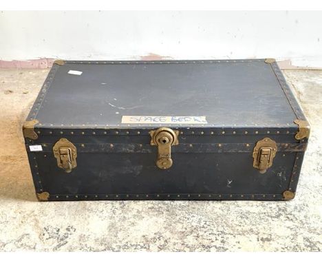 An early to mid 20th century steamer trunk, with leather carry handle to each end, H34cm, W93cm, D51cm