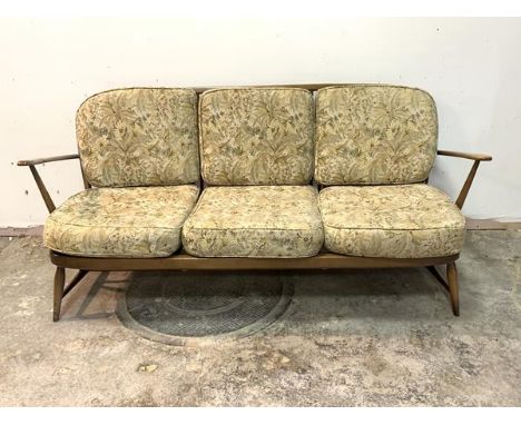 Ercol, A stained beech framed three seat sofa with upholstered squab cushions, H77cm, W170cm, D70cm