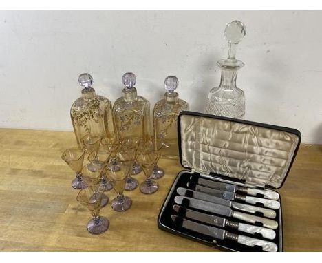 A mixed lot including three decanters with gilt and enamel foliate decoration each measures 19cm high and eleven matching liq