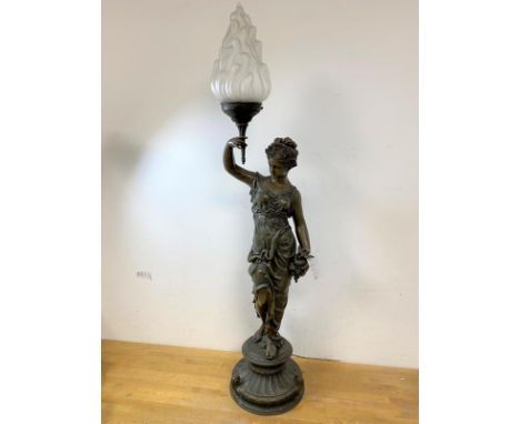 An Edwardian spelter Greek style lamp of lady holding a flaming torch with opaque glass shade on moulded circular base, measu