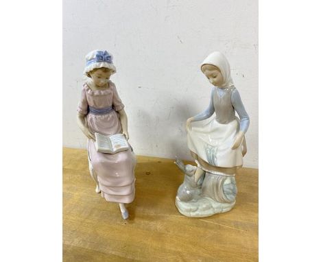Two Lladro figures, one of girl sitting reading book, measures 24cm high the other of girl with rabbit (2)