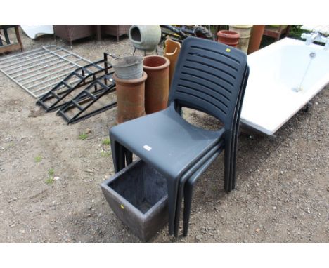 Three plastic garden chairs and a planter