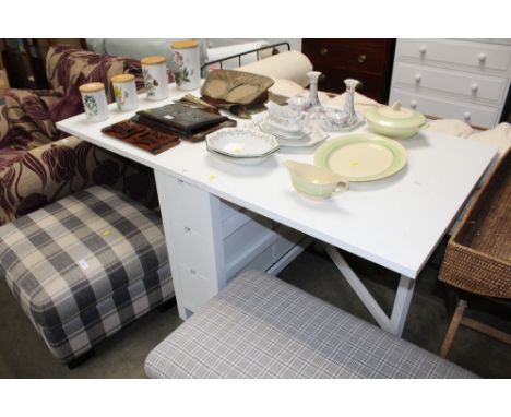 A modern white gate leg table fitted three drawers 