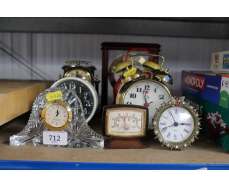 A collection alarm clocks and a mantel clock