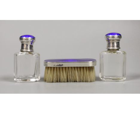 A pair of George V silver and enamel mounted glass scent bottles, 73mm and a small mounted brush, London, 1926.