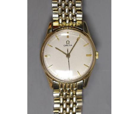 A gentleman's 9ct gold Omega manual wind wrist watch, on an Omega steel and gold plated bracelet, with box and pamphlets.