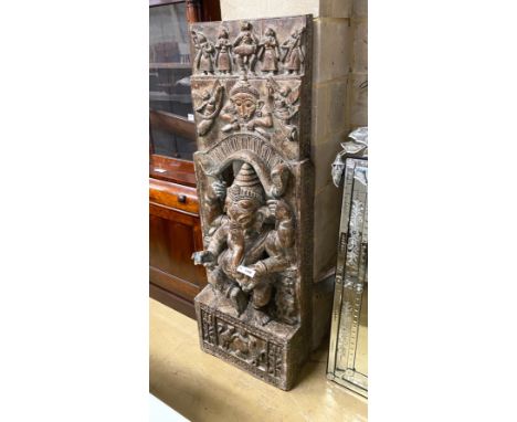 An Indian stained and carved hardwood panel centred with Ganesh, width 54cm, height 160cm