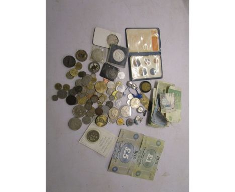 A selection of coinage from around the world, banknotes and enamel badges to include a Kitzbuhel Ski School badge, a one doll