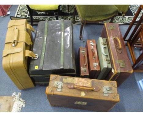 A group of vintage leather suitcases and a tin trunk