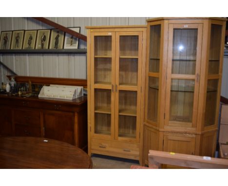 A light oak and glazed cabinet fitted single drawer below 