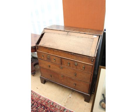 A GEORGIAN OAK BUREAU the fall front opening to reveal pigeon holes and small drawers above two short and two long drawers, s