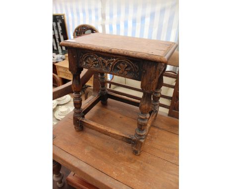 AN OAK STOOL of pegged construction with a rectangular top and turned legs united by a stretcher 45cm wide x 47cm high 