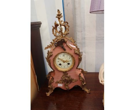 A PINK STONE AND ORMOLU MOUNTED CONTINENTAL MANTLE CLOCK with scroll decorated case, the enamel dial with Arabic numerals and