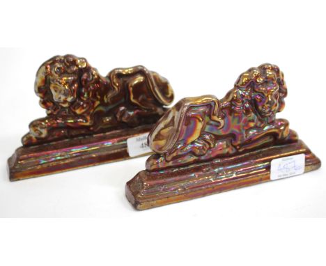 A PAIR OF CAST IRON ENAMEL DECORATED DOOR STOPS in the form of recumbent lions, each 19.5cm wide (2)