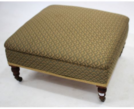 A SQUARE OVERSTUFFED UPHOLSTERED STOOL with turned legs and ceramic castors 67cm wide 