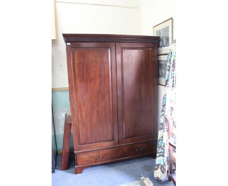 A 19TH CENTURY MAHOGANY, POSSIBLY CHANNEL ISLANDS, WARDROBE with carved frieze, twin panelled doors over a single long drawer