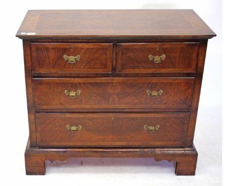 A REPRODUCTION WALNUT CHEST of two short and two long drawers with cross banded top and standing on bracket feet 88cm wide x 