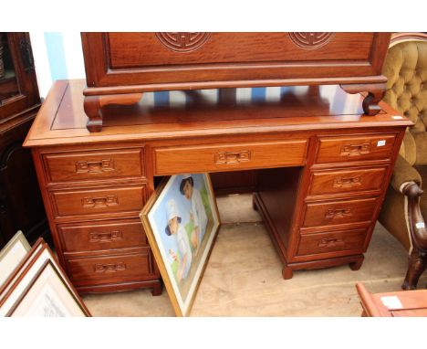 A CHINESE HARDWOOD PEDESTAL DESK with nine drawers around a central knee hole, each drawer with carved inset handles and each