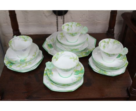 A 1930'S PARAGON PART TEA SERVICE, modern shape with a flower shaped handle with green floral decoration to include four cups