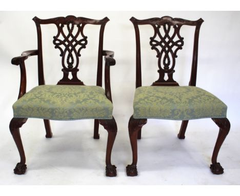 A SET OF EIGHT CHIPPENDALE STYLE MAHOGANY DINING CHAIRS with ribbon carved pierced splat backs, overstuffed upholstered seats