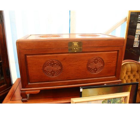 AN ORIENTAL HARDWOOD BLANKET BOX with panelled top and sides, standing on short ogee bracket feet 101cm wide x 61cm high
