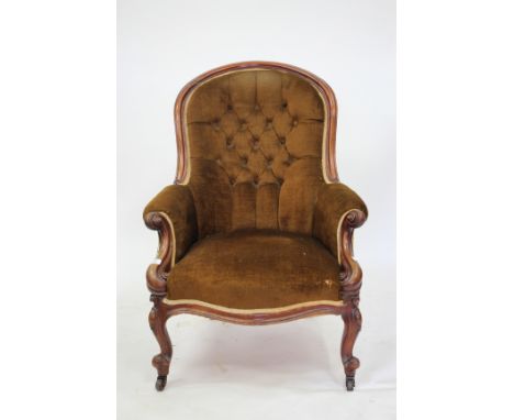AN EARLY VICTORIAN MAHOGANY FRAMED LOW BUTTON UPHOLSTERED ARMCHAIR with scrolling arms, scrolling cabriole feet and brass cas