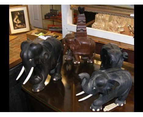 A carved ebony Elephant, together with two others and an Elephant table lamp  