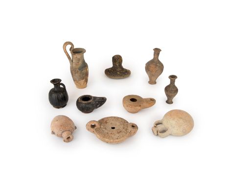 A group of pottery vessels, Circa 1400 B.C. – 2nd Century A.D.,Including an Egyptian or Phoenician heart-shaped flask with um