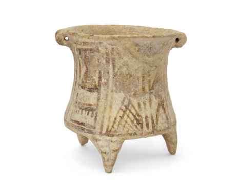 An intact Luristan pottery tripod vessel,North Iran, circa 2000-1,500 B.C.,with concave sides and a single pierced side loop 