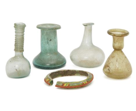 Four small Roman glass vessels and a banglecirca 2nd-4th century AD.Including a pale blue spherical-bodied unguentarium, trai