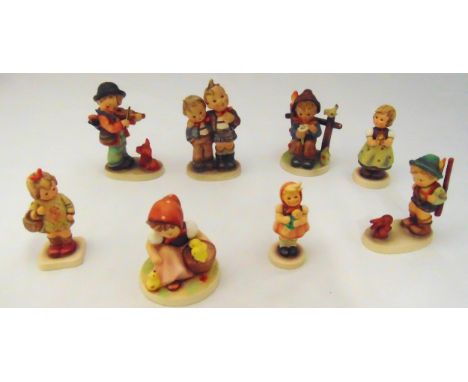 Eight Goebel figurines of children in various poses on oval bases