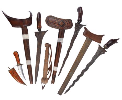 Three Indonesian daggers (kris), the first with flamboyant blade 14.5 in, wooden hilt of garuda type, the stem of the scabbar