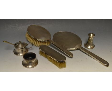 A silver three piece engine turned cruet set, Birmingham 1936; a silver mounted three piece dressing table set, Birmingham 19
