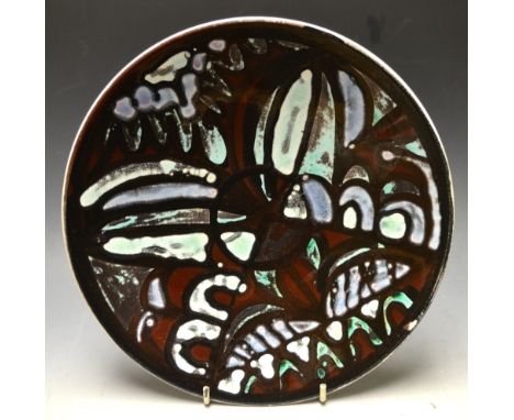 A Poole pottery dished circular bowl, painted with stained glass effect panels, printed marks, signed to verso, 27cm diam