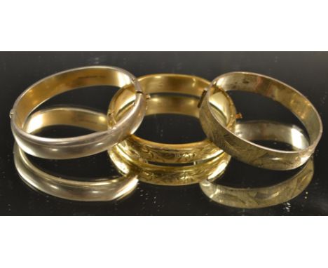 Two silver hinged bangles; a rolled gold bangle (3)

