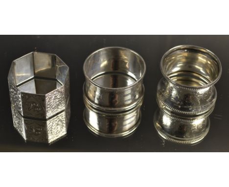 A Victorian silver octagonal napkin ring, chased with all over foliate motifs, Birmingham, 1886; others (3) 