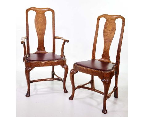 A set of six Queen Anne style light oak dining chairs, comprising four single and two open arm carvers, each with vase-shaped