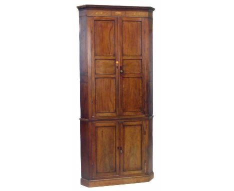 George III mahogany double floor standing corner cupboard, dentil cornice with oval inlays of flower heads, panel doors with 