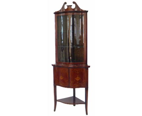 Edwardian mahogany double floor standing serpentine front display cabinet, the top section with swan neck pediment, single gl