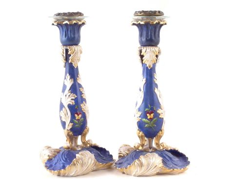 Pair of Paris porcelain rococo candlesticks, painted with flora on blue grounds, mid 19th century.26cm high Condition report: