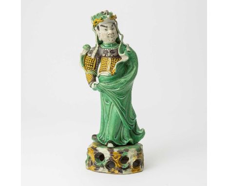The standing figure in yellow and aubergine glazed armor wrapped in a flowing green cloak figure modeled atop an openwork roc